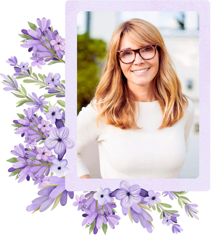 Framed portrait of a smiling therapist with glasses and a cream knit top, held in a pale-lavender watercolor frame with a cluster of lilac flowers running down the left side